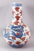 A LARGE UNDERGLAZED BLUE AND COPPER RED DRAGON VASE, painted with dragons amongst clouds, six