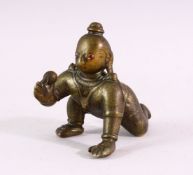 A SMALL EARLY CAST BRONZE INDIAN CROUCHING FIGURE, with inset gold and ruby eyes, 9cm long.