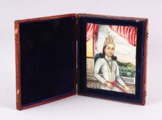 A 19TH CENTURY INDIAN PORTRAIT MINIATURE OF A SEATED GENTLEMAN, painted on ivory in a leather