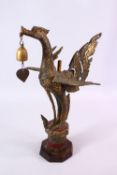 AN INDONESIAN CAST AND GILDED TEMPLE BELL IN THE FORM OF A BIRD standing with outspread wings and