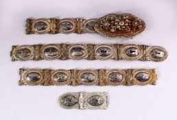A RUSSIAN NIELLO DECORATED WHITE METAL BELT with highly ornate filigree buckle and sixteen joined