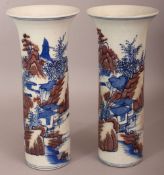 A PAIR OF CHINESE COPPER-RED & UNDERGLAZE-BLUE CYLINDRICAL PORCELAIN VASES, each decorated with a