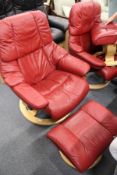 A good Stressless red leather upholstered swivel armchair with matching foot stool.