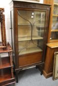 A mahogany standing display cabinet.