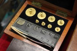 A small mahogany box containing gold weights.