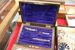 A mahogany box containing a small quantity of drawing instruments.