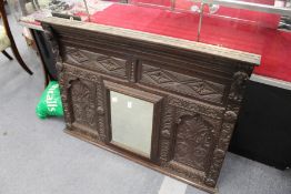 A carved oak over mantle mirror.