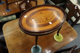 A mahogany and marquetry oval low table inlaid with a classical urn and floral swags.