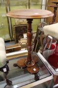 A 20th century mahogany circular occasional table with column support on a trefoil shaped base