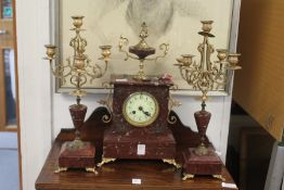 A late 19th century rouge marble and ormolu clock garniture.