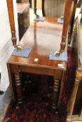 A 19th century mahogany drop leaf gate leg dining table on turned legs.
