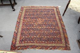 A small Persian Mashad rug, dark blue ground with rows of stylized decoration.