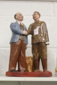 A Russian pottery group of two standing figures.