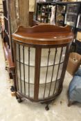 A mahogany bowfront display cabinet.