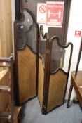 An Edwardian carved mahogany three panel folding dressing screen with part glazed and part