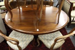 A Victorian mahogany oval tilt top breakfast table on a carved base with four carved curving legs.