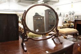 An oval dressing table mirror.