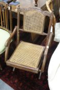 A folding cane seated armchair.