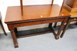 A mahogany console table with two frieze drawers on gun barrel turned front legs united by an H-