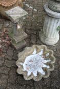 A shell shaped bird bath top together with a classical style pedestal base.