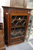 A 19th century mahogany hanging corner cabinet with glazed door.