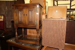 A small oak two door cupboard and a linen basket.