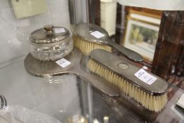 A four piece silver dressing table set comprising hand mirror, powder bowl and cover and two