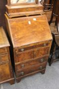 A mahogany bureau of small size with fitted interior above an arrangement of three drawers and two