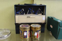 A pair of decorative tins and a case of records.