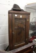 A small oak hanging corner cabinet.