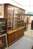 A good 19th century oak library cupboard bookcase with dentil moulded cornice, four glazed doors