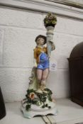 A continental porcelain figure holding a cornucopia of flowers.