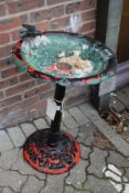 A painted cast metal bird bath.