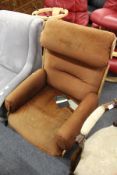 A Charles Eames style moulded plywood and upholstered swivel armchair.