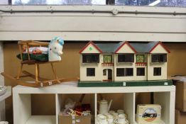 A doll's house with accessories together with a child's rocking chair.