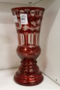 A Bohemian red tinted glass vase with engraved decoration.