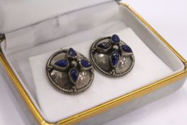 A pair of shield shaped earrings.