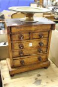 A miniature oak chest of drawers.