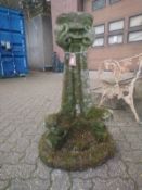 A weathered reconstituted stone garden planter.