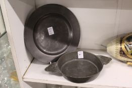A pewter twin handled bowl and a circular plate.