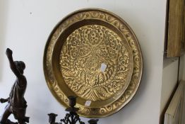 An Arts & Crafts embossed brass circular dish.