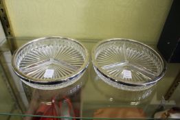 A pair of moulded glass hors d'oeuvres dishes with plated rims.