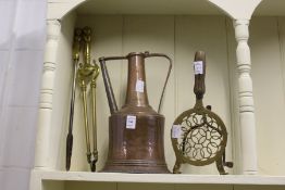 A copper ewer, brass trivet, tongs and a poker.