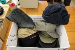 A quantity of military caps and other head gear.