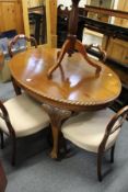 A mahogany oval breakfast table on four carved cabriole legs with claw and ball feet.