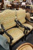 A near pair of open armchairs with carved ebonised frames.