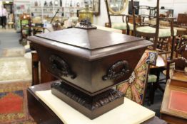 A good mahogany sarcophagus cellarette with carved decoration to the top, carved laurel wreath