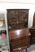 A George III mahogany bureau with associated bookcase top.