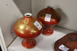 An unusual pair of Japanese gilt decorated red bulbous shaped vases.
