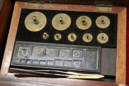 A small mahogany box containing gold weights.